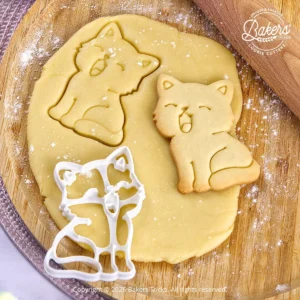 Pâte sablée découpée avec un emporte-pièce Bakers'Tricks et biscuit sablé en forme de chat qui bâille.