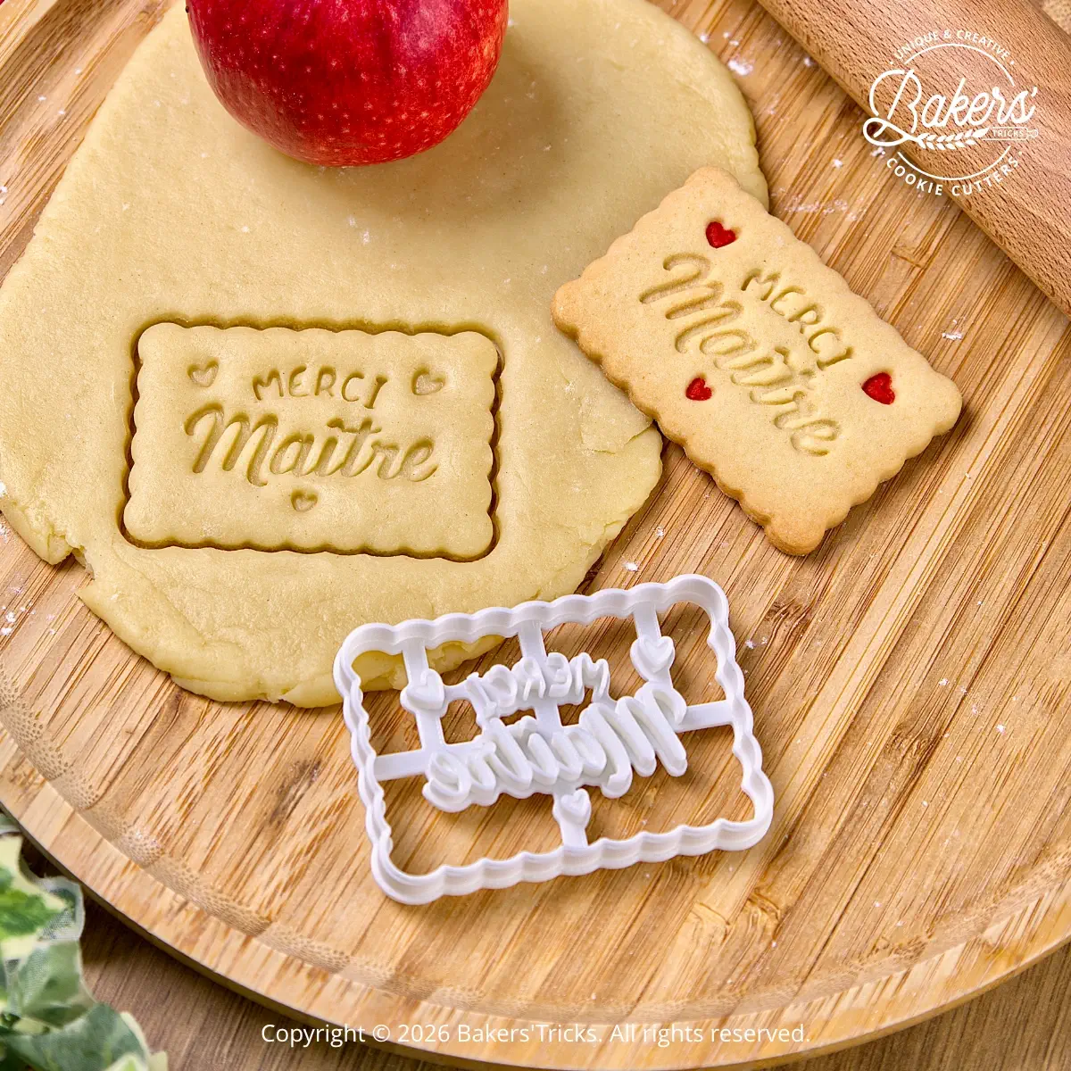 Merci Maître cookie cutter shown with cut-out cookie dough before baking, designed as a thank-you gift for a teacher.