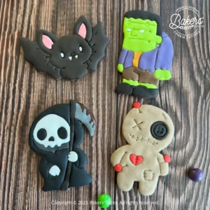 Biscuits d’Halloween décorés en pâte à sucre représentant une chauve-souris, Frankenstein, une faucheuse et une poupée vaudou.