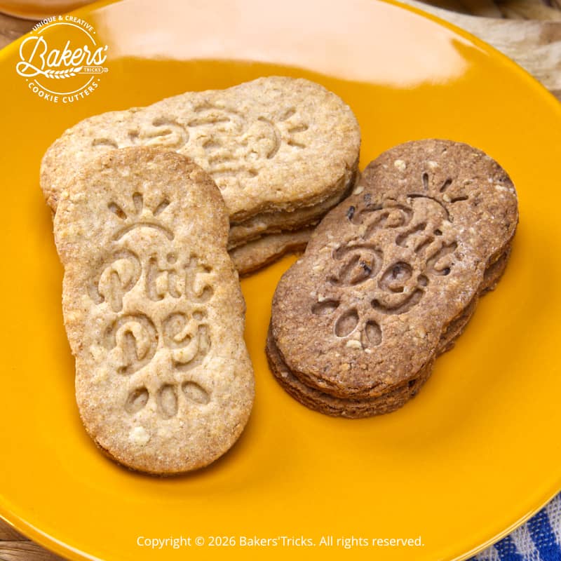 Biscuits aux céréales faits maison marqués “Ptit Dej” réalisés avec emporte-pièce, version nature et chocolat, présentés sur assiette