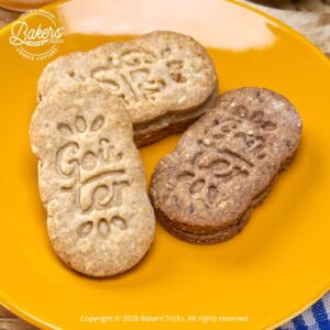 Biscuits aux céréales faits maison marqués “Goûter réalisés avec emporte-pièce, version nature et chocolat, présentés sur assiette