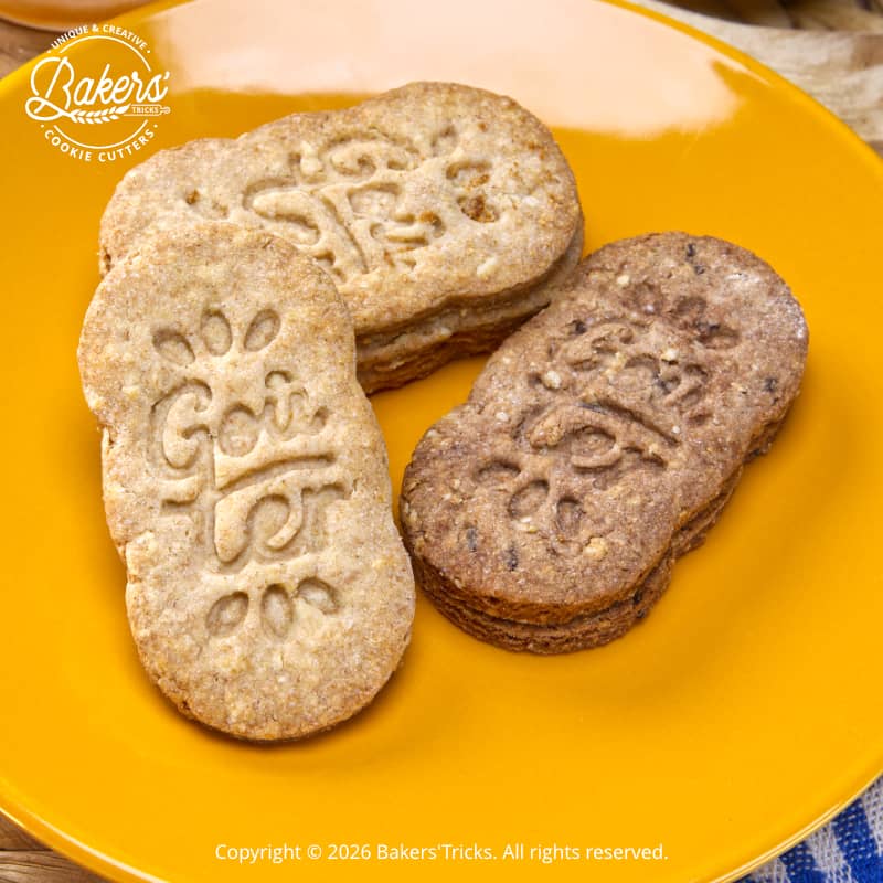 Biscuits aux céréales faits maison marqués “Goûter réalisés avec emporte-pièce, version nature et chocolat, présentés sur assiette
