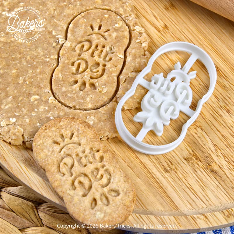 Emporte-pièce biscuit Ptit Dej utilisé sur pâte aux céréales pour créer des biscuits petit-déjeuner faits maison, avec empreinte visible et découpe nette
