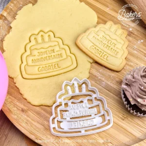 Emporte-pièce biscuit gâteau joyeux anniversaire personnalisé avec prénom. Découpe de pâte sablée avant cuisson et biscuit d’anniversaire maison fini en forme de gâteau avec bougies. Idéal pour créer des biscuits personnalisés pour anniversaire.